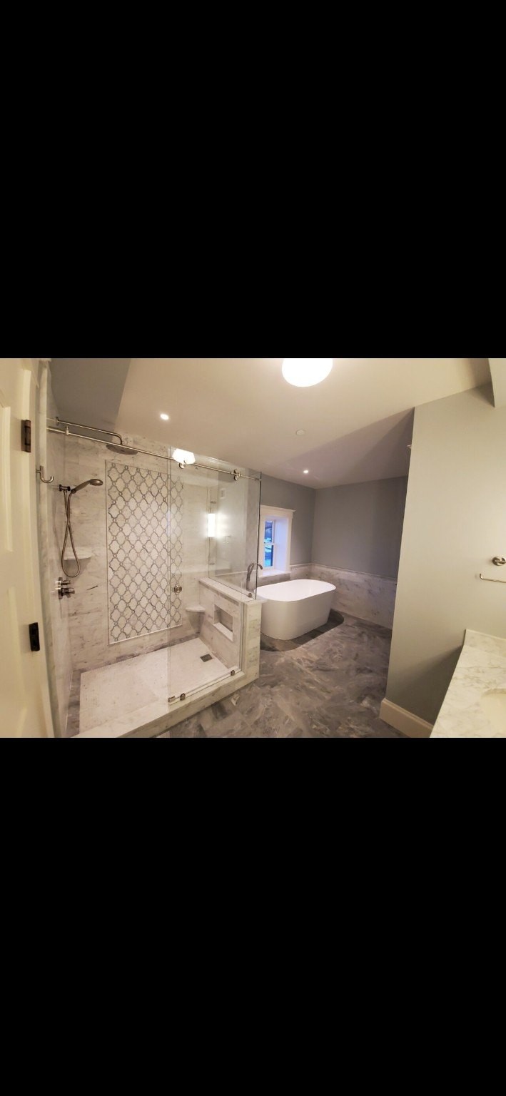 Large bathroom with marble shower and freestanding tub